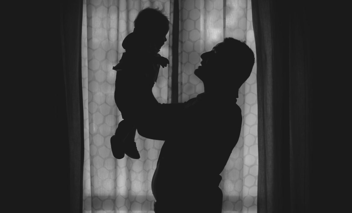 un homme porte son bébé dans les bras après un test de paternité